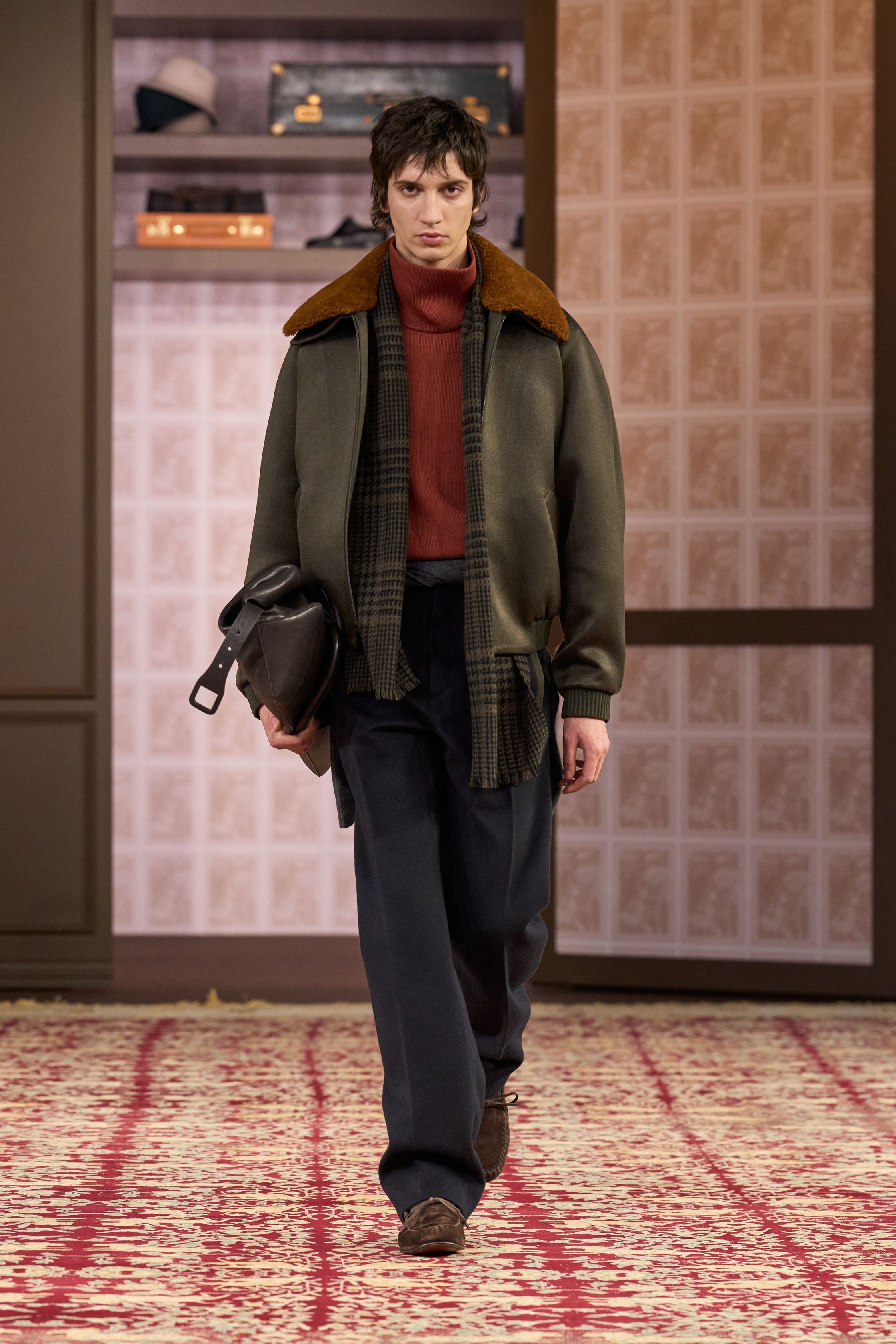 ZEGNA 2026秋冬以“安静权威”为核心命题，在高度私密、近乎沙龙式的空间中重塑当代男性精英形象。柔和灯光下，西装、大衣与针织被处理得异常克制，廓形松弛却精准，强调肩线的自然下垂与裤装的流动垂感。羊毛、羊绒与精纺面料成为绝对主角，色彩集中于驼色、烟灰、深橄榄与夜黑，传递一种无需证明的自信。这一季ZEGNA不谈趋势，而是提出一种长期有效的男性着装秩序——成熟、内敛、经得起时间审视的“当代绅士体系”-顽石频道趋势研究